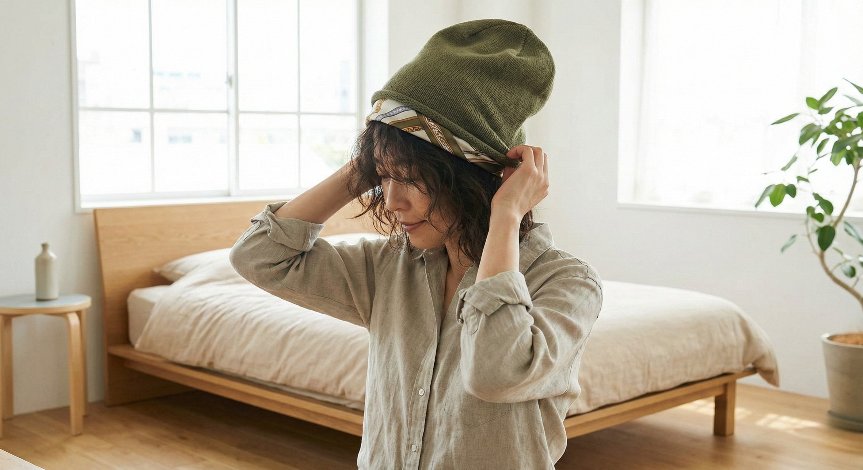 Woman wearing a breathable cap over a silk scarf lining to protect hair edges