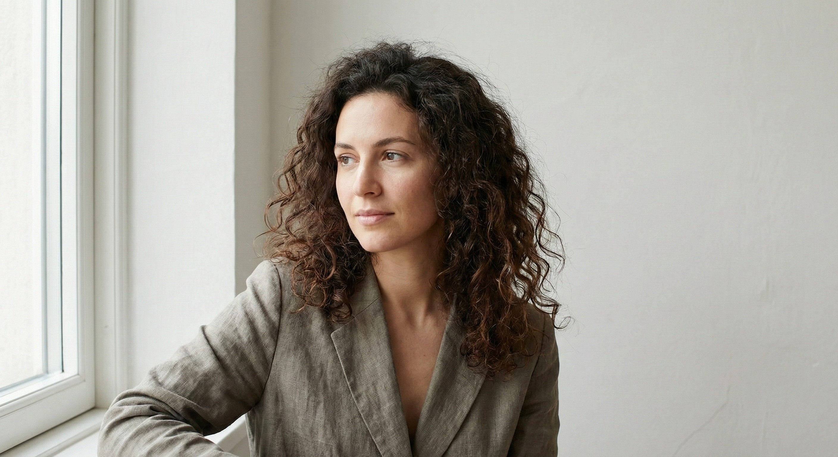 Woman with subtly frizzier, less defined curls showing texture change from dryness and damage