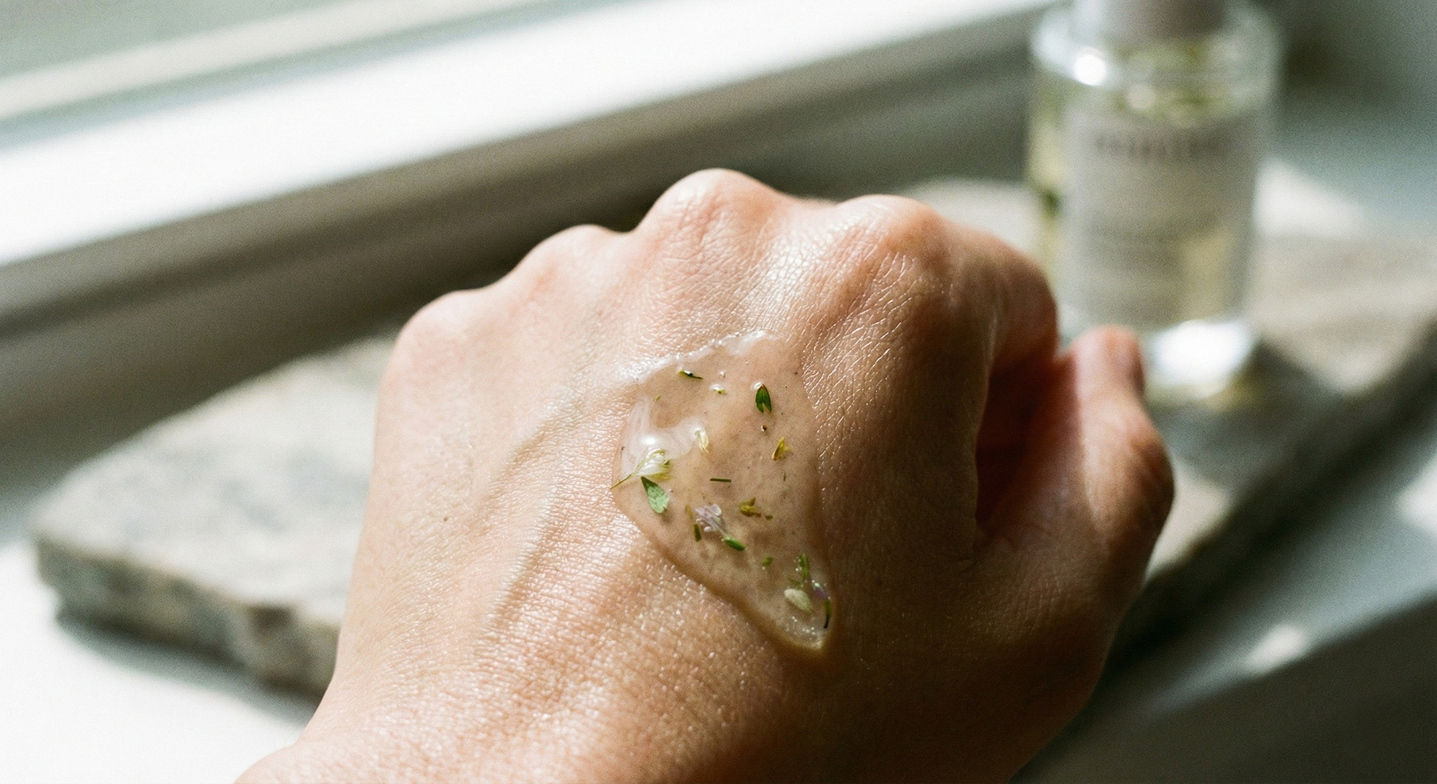 Close up image of a lightweight botanical extract serum absorbing into skin, showing a non greasy scalp care formula.